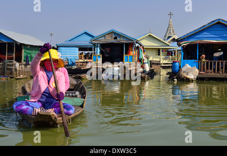 Kambodschanische Frau paddelt mit ihrem Holzboot vor den schwimmenden Häusern und Hausbooten auf dem Tonle SAP See, zwischen Battambang & Siem Reap, Kambodscha Stockfoto