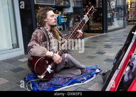 Junger Mann spielt Sitar und Straßenmusik in der Sauchiehall Street, Glasgow, Schottland, UK Stockfoto