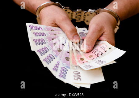 Mann in Handschellen hält eine Brieftasche mit Banknoten und Kreditkarten Stockfoto