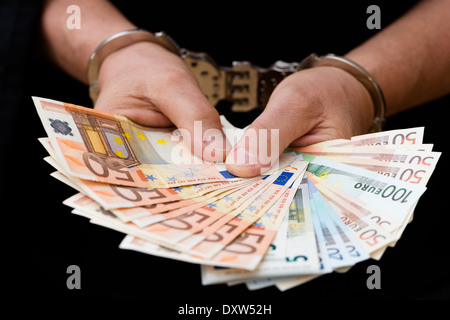 Mann in Handschellen hält Euro-Banknoten Stockfoto