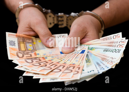 Mann in Handschellen hält Euro-Banknoten Stockfoto