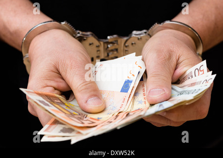 Mann in Handschellen hält Euro-Banknoten Stockfoto