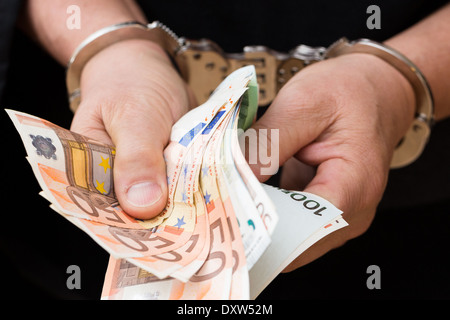 Mann in Handschellen hält Euro-Banknoten Stockfoto