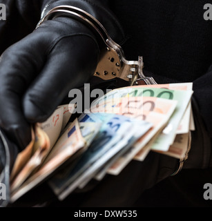 Nahaufnahme der Hände mit Handschuhen in Handschellen halten Brieftasche mit EUR Stockfoto