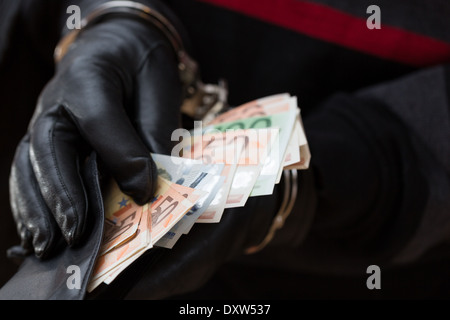 Nahaufnahme der Hände mit Handschuhen in Handschellen halten Brieftasche mit EUR Stockfoto