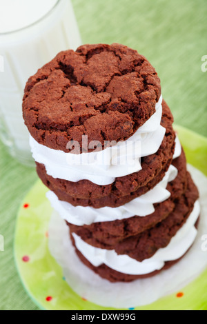 Ein Stapel von Creme gefüllte Schokoladen-Cookies und ein großes Glas kalte Milch. Stockfoto