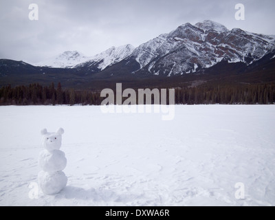 Ein Blick auf eine Snowbear (Schneemann) auf gefrorenen Pyramid Lake im Jasper Nationalpark, Kanada. Pyramide-Berg erhebt sich im Hintergrund. Stockfoto