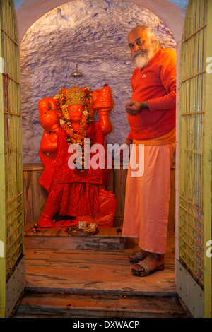 Indien, Dehradun. Hanuman, ein Hindu-Gottheit in der Tapkeshwar-Hindu-Tempel mit Hindu Priester. Stockfoto