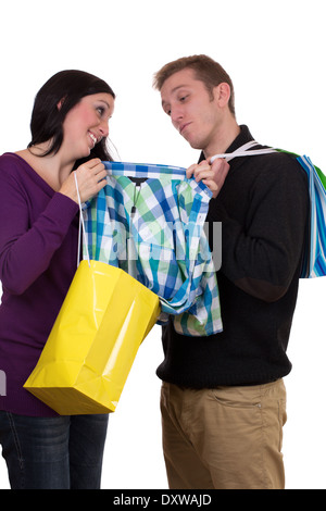 Junge Frau mit Taschen zeigen ihre Freundin ein Hemd während shopping, isoliert auf weißem Hintergrund Stockfoto