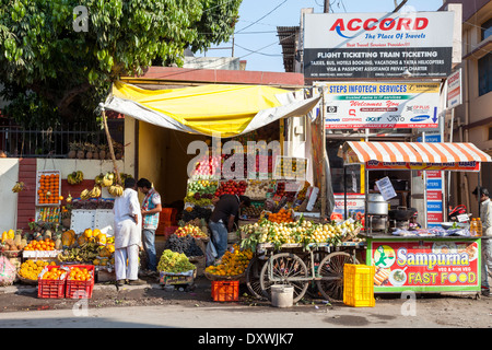 Indien, Dehradun. Straßenszene - Fast-Food, Obst stehen, Reisebüro. Stockfoto