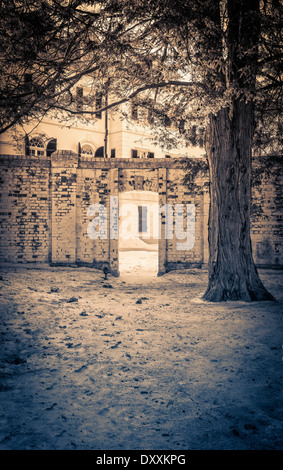 Eine Wand vor einem goldenen Zeitalters Herrenhaus mit Schnee und Bäumen. Stockfoto