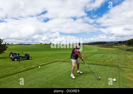 Ein Golfer fährt vom Abschlag auf einem ländlichen Golfplatz in Kwazulu Natal in Südafrika seine Golf-Cart im Hintergrund ist Stockfoto