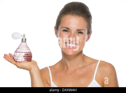 Glückliche junge Frau zeigt Parfüm-Flasche Stockfoto