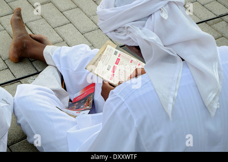 Arabische Mann Kommissionierung Pferde beim Dubai World Cup Pferderennen Meisterschaft in Meydan Racecourse in Dubai Vereinigte Arabische Emirate Stockfoto