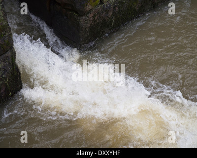 Nahaufnahme von kleinen Wasserfall im Frühling, Wasser Rauschen, braune Erde durchzuführen Stockfoto