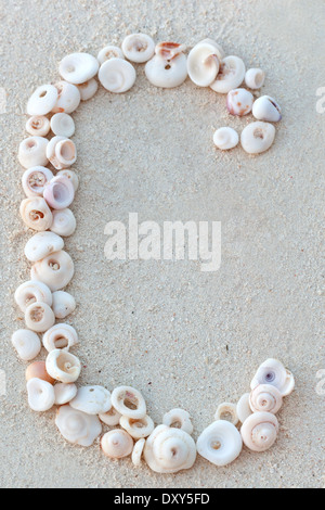 Shell-Alphabets am Sandstrand, Nahaufnahme Stockfoto