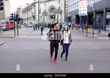 Junger Mann & Frau Kreuzung Straße vom Bahnhof Waterloo Stockfoto