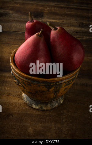 Anjou rote Birnen in rustikalen Schüssel auf rustikalen Holz Stockfoto