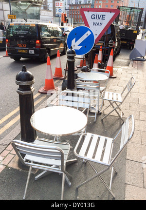 Tische und Stühle neben Straßenarbeiten vor einem Café im Stadtzentrum von Birmingham. Stockfoto