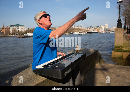 Straßenmusiker spielen eine elektronische Orgel singen am Flussufer. South Bank, London, UK. Stockfoto