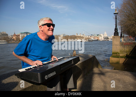 Straßenmusiker spielen eine elektronische Orgel singen am Flussufer. South Bank, London, UK. Stockfoto