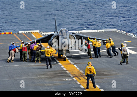 US-Matrosen und Marinesoldaten bringen eine AV-8 b Harrier-Flugzeuge in Position auf dem Flugdeck während des Betriebs auf amphibischer Angriff Schiff USS Peleliu 27. März 2014 im Pazifischen Ozean. Stockfoto