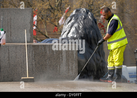 London, England, Vereinigtes Königreich. Arbeiter in hi-Vis-Jacke, die Reinigung der Basis des Nelson Säule mit einem macht-Schlauch Stockfoto