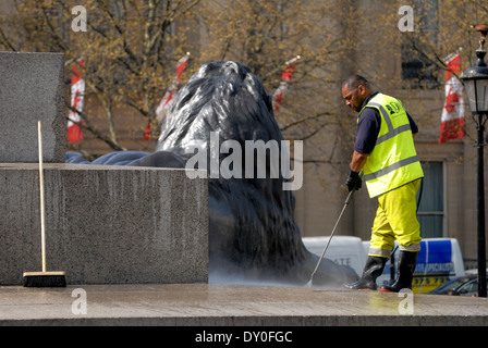 London, England, Vereinigtes Königreich. Arbeiter in hi-Vis-Jacke, die Reinigung der Basis des Nelson Säule mit einem macht-Schlauch Stockfoto