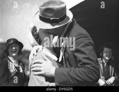 Ein historisches Foto aus dem Moment, als Spieler des Western Suburbs Rugby League Football Club am 19. September 1934 nach Neuseeland aufbrachen. Das Bild zeigt einen zärtlichen Abschied mit einem Kuss zwischen einem Fußballspieler und seiner Frau im Hafen von Sydney. Stockfoto
