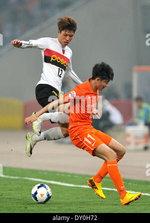 Jinan, China Shandong Provinz. 2. April 2014. Kim Seung Dae (L) der südkoreanischen Pohang Steelers wetteifert mit Wang Tong von Chinas Shandong Luneng während ihrer AFC Champions League-Gruppe E-Fußballspiel in Jinan, der Hauptstadt der ostchinesischen Provinz Shandong, am 2. April 2014. © Xu Suhui/Xinhua/Alamy Live-Nachrichten Stockfoto