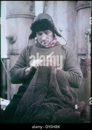Dieses Foto von Frank Hurley aus dem Jahr 1915 zeigt John Vincent, die Bosun an Bord der „Endurance“, während Sir Ernest Shackletons Antarktis-Expedition ein Netz repariert. Das Bild fängt einen wichtigen Moment der anspruchsvollen Reise ein. Stockfoto