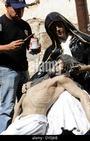 Ein Handwerker erfrischt sich Figuren von Jesus und Maria für Prozessionen in der Semana Santa, der Karwoche, in Antigua. Stockfoto