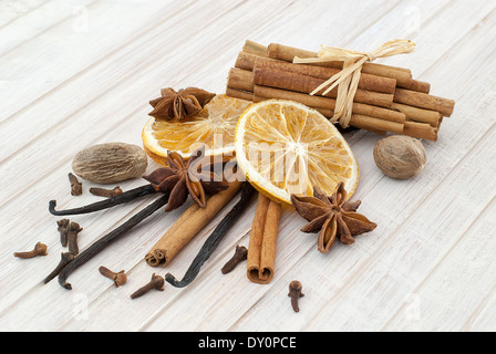 Trockenen Orangenscheiben, Zimtstangen, Piment, Vanille, Anis und Nelken auf weißer Holztisch. Stockfoto