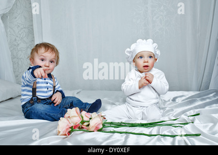 Niedlichen Bruder und Schwester spielen auf einem Bett mit Seidenlaken im Kinderzimmer Stockfoto