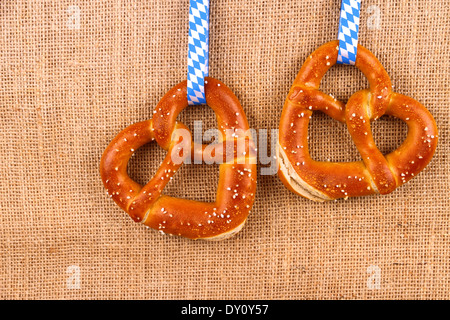 Zwei Brezel in Herzform auf Jute Hintergrund, Ansicht von oben Stockfoto