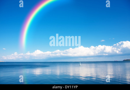 Regenbogen am blauen Himmel über endlose Wasser Stockfoto