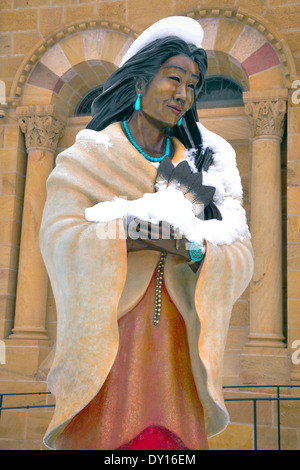 Bronzestatue des heiligen Kateri, türkis in verschneiten Szenen, die vor der Dombasilika des heiligen Franz von Assisi, Santa Fe, NM steht Stockfoto