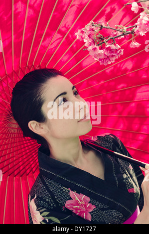 Hanami Kirschblütenschau in Okinawa, Japan. Junge Frau trägt japanische traditionelle Yukata (Sommer-Kimono) Stockfoto