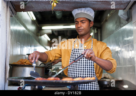 Leh, Ladakh, Indien. Ein Koch bereitet frittierte Speisen aus einem Hole-in-Shop im Basar Stockfoto