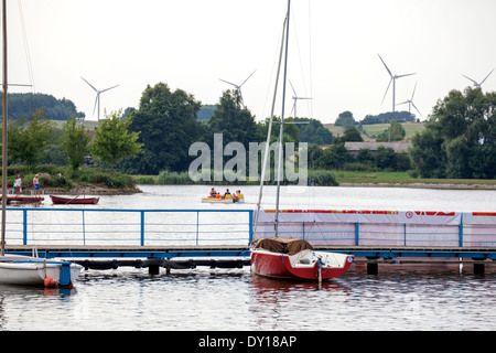 Windkraftanlagen Sie zur Stromerzeugung mit Blick auf Zalew Tatar Lagune und die Stadt am Wasser. Rawa Mazowiecka Zentralpolen Stockfoto