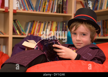 7 Jahre alten Schüler lesen in der Schule Bibliothek in Kostüm für Welttag des Buches 2014, Haslemere, Surrey, Großbritannien. Stockfoto