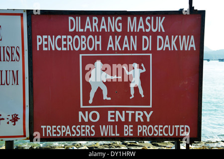 Eindringlinge werden strafrechtlich verfolgt, Warnschild, der Insel Langkawi, Kedah, Malaysia. Stockfoto