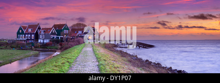 Kleines Dorf hinter einem Deich, fotografiert auf der Insel Marken in den Niederlanden bei Sonnenaufgang Stockfoto