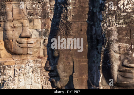 Drei geschnitzte steinernen Gesichter im Bayon-Tempel in Angkor in der Nähe von Siem Reap, Kambodscha Stockfoto