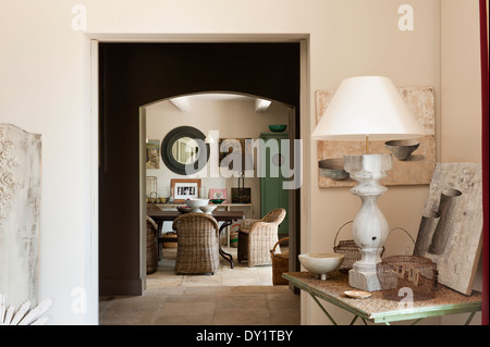 Blick vom Salon durch Dining room mit Steinböden. Eine steinerne Lampe sitzt auf einem schmiedeeisernen Klapptisch in der Ecke Stockfoto