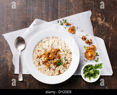 Risotto mit Pfifferlingen auf Holztisch Stockfoto