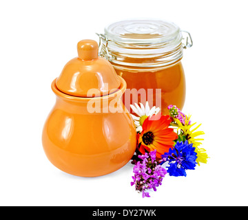 Honig in einem Tonkrug und ein Glas mit Blumen isoliert auf weißem Hintergrund Stockfoto