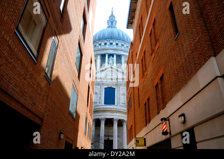 London, England, Vereinigtes Königreich. St. Pauls Cathedral gesehen zwischen zwei moderne, Backstein Gebäude in Queen es Head Passage Stockfoto