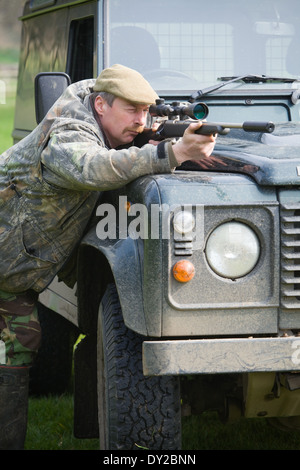 Ein Spiel-Keeper Schädlinge im Laufe des Tages von einem Land Rover Fahrzeug mit einem Gewehr schießen Stockfoto