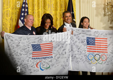 US-Präsident Barack Obama und First Lady Michelle Obama sind Banner von uns Paralympischen und Olympiateilnehmer im East Room des weißen Hauses 3. April 2014 in Washington D.C. unterzeichnet vorgestellt. Die ersten paar präsentierte einen Banner Behindertensportler und ehemaligen Marine Sgt. Jon Lujan und Julie Chu, die Silber in Sotschi mit den Frauen Olympische Hockey-Team gewann. Stockfoto